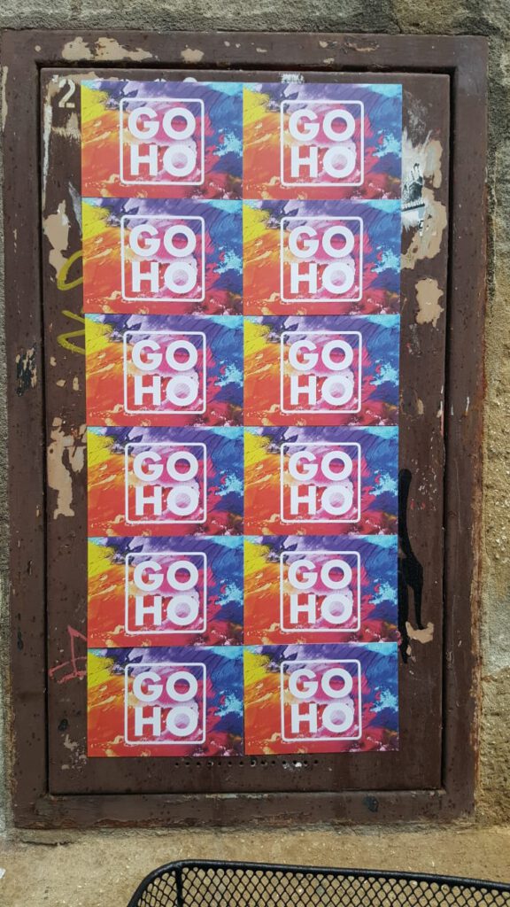 Die bunten GOHO-Postkarten zieren eine rostige Tür