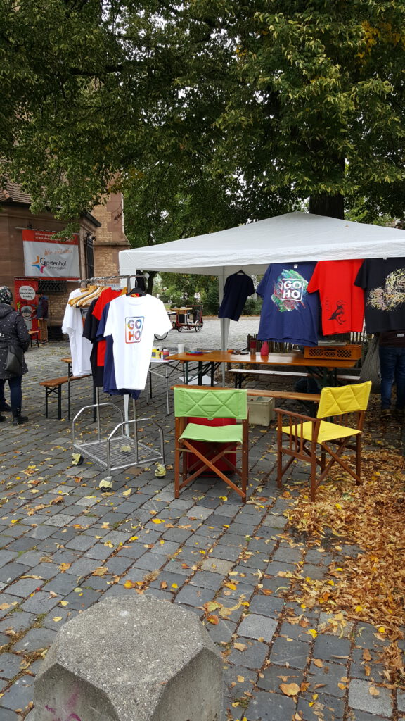 ein Stand mit Siebdruckwerkstatt auf einem gepflasterten Platz